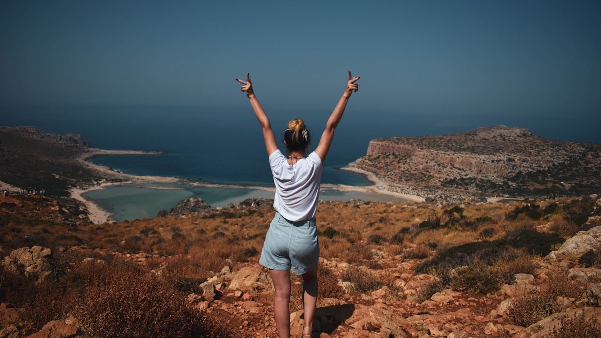 a woman standing on top of a rocky hillside